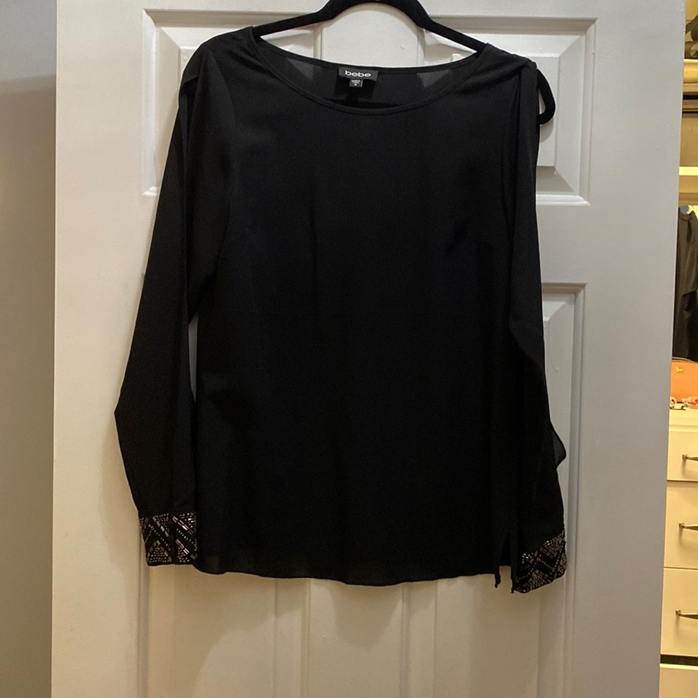 Bebe black top with embellished cuffs and slits down the arm.